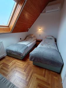 Dos camas en una habitación con ventana. en SZEKI Apartman, en Gyula