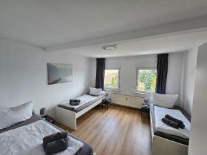 Zimmer mit 2 Betten und 2 Fenstern in der Unterkunft High Moon Apartment House in Nienburg with Wifi in Grimschleben