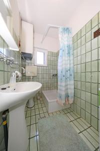 a bathroom with a sink and a shower curtain at Apartments Marijana in Vodice