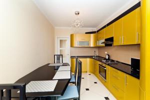 uma cozinha com armários amarelos, uma mesa e cadeiras em Flowers Apartments - Large and Spacious em Chisinau