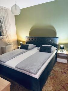 a bedroom with a large bed with a blue headboard at Villa AYA - with sauna and outdoor swimming pool in Mostar