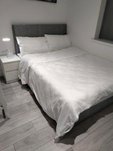 a bedroom with a bed with white sheets and a lamp at Oceanik in Dublin