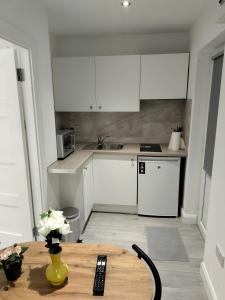 a kitchen with white cabinets and a wooden table at Oceanik in Dublin