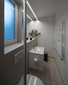 bagno con lavandino e specchio di outsideIN Lightstudio a Zagabria