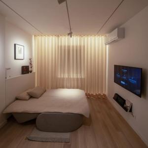 una camera con un grande letto e una televisione di outsideIN Lightstudio a Zagabria
