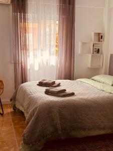 a bedroom with a bed with two towels on it at Casa de Mila in Alicante