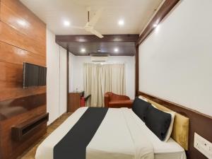 a bedroom with a bed and a tv and a couch at Collection O SRD Resort in Goa