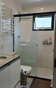 a bathroom with a toilet and a glass shower at bwelcome - aconchego pé na areia mod 2 in Bertioga +16 photos