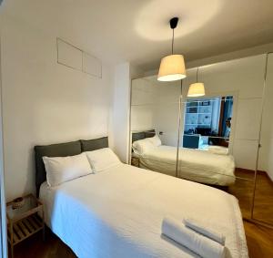 Un dormitorio con una gran cama blanca y un espejo. en Flaminia home, en Roma