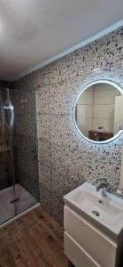ein Bad mit einem Waschbecken und einem Spiegel in der Unterkunft Apartament Wojska Polskiego in Starachowice