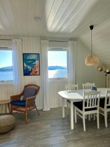 a dining room with a white table and chairs at Waterfront Rorbu - By the Beach in Bud