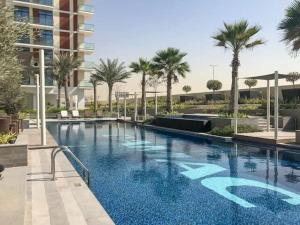 una gran piscina con palmeras y un edificio en Frank Porter - Damac Celestia, en Dubái