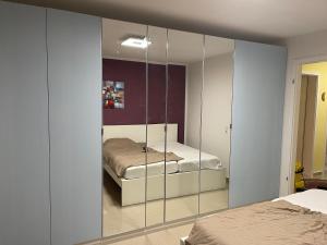 a bedroom with a mirrored cabinet with a bed at Ferienwohnung Köln in Cologne