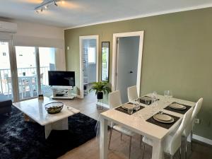 a dining room with a white table and chairs at Edf. 4 caminos in Nerja