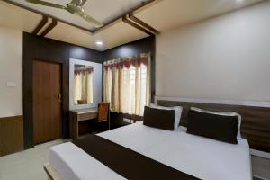 1 dormitorio con 1 cama grande y escritorio en OYO Anusuya Hotel en Bhubaneshwar