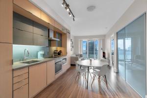 a large kitchen with a table and a dining room at Rare 1BR - Rooftop Pool, Next to MTCC & CN Tower in Toronto