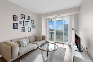 a living room with a couch and a glass table at Rare 1BR - Rooftop Pool, Next to MTCC & CN Tower in Toronto