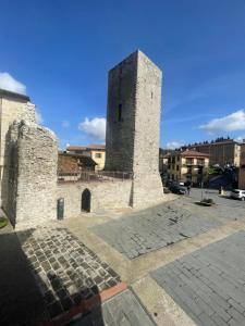 a building with a tower in the middle of a street at LocAle Guest House in Pietralunga