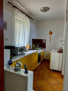 kuchnia z żółtymi szafkami i kuchenką mikrofalową w obiekcie Cabana Oana 5-bedrooms chalet w mieście Arad