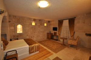 a bedroom with a bed and a table and a chair at Goreme Inn Hotel Only Adult in Göreme