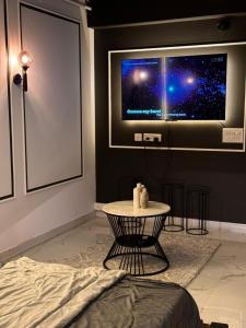 een kamer met een tv aan een muur met een tafel bij BnW studio - Cozy & Complete in Ghaziabad