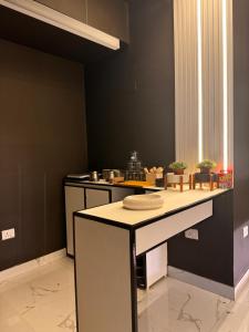 een keuken met zwarte muren en een aanrecht bij BnW studio - Cozy & Complete in Ghaziabad