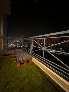 een bank die 's nachts op een balkon zit bij BnW studio - Cozy & Complete in Ghaziabad