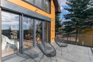 twee stoelen op een patio naast een huis bij Mátra Zenit in Mátraszentimre