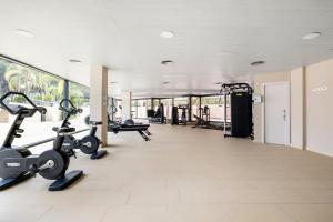 un gimnasio con cintas de correr y elípticas en un edificio en Special Complex Sol Cambrils, en Cambrils