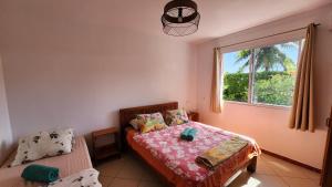 a bedroom with a bed and a window at La Maison Orange in Moorea