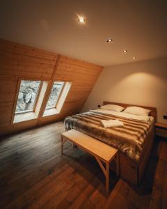 een slaapkamer met een groot bed en 2 ramen bij The Cozy Chalet in Bosanski Petrovac
