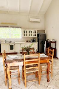 cocina con mesa de comedor de madera y sillas en Maison 79 en Soufrière