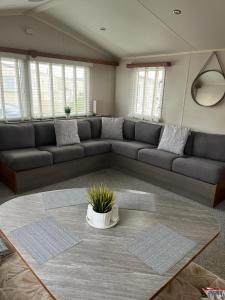 a living room with a couch and a table at 3 bed Stunning caravan situated nr Whitstable in Whitstable