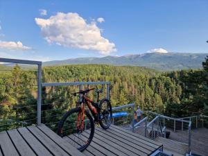 a bike parked on a deck with a view of the mountains at Przystanek w kolorach świata in Jelenia Góra