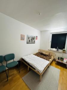 um quarto com uma cama, uma cadeira e uma janela em Cozy room in a shared apartment close to nature em Gotemburgo