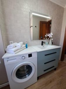a bathroom with a washing machine and a mirror at Mi casita del norte in Mogro