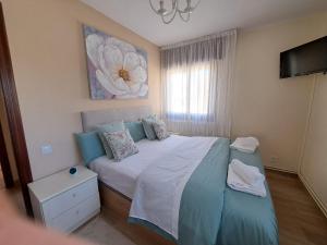 a bedroom with a large bed with a flower painting on the wall at Mi casita del norte in Mogro