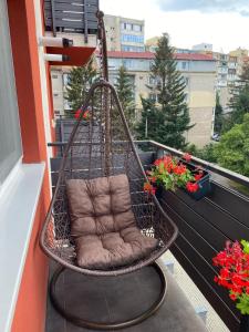 einen Hängesessel auf einem Balkon mit Blumen in der Unterkunft Premium Studio MV in Sibiu