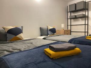 a bedroom with two beds with a yellow blanket on the floor at Apartment Roomy Comfort - Zwischen Heidelberg und Mannheim in Edingen-Neckarhausen