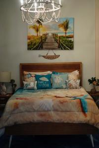 圣胡安The Suites & Vintage Apartment at Casa Of Essence in heart of Old San Juan的卧室里有一张床，墙上挂着一幅画
