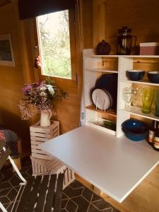 uma cozinha com uma mesa branca num quarto em Cosy Shepherds hut Between Maple and Hawthorn em Mountshannon