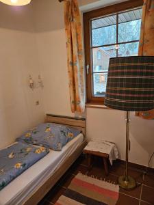 a bedroom with a bed and a window and a lamp at Haus Annaburg in Mariazell