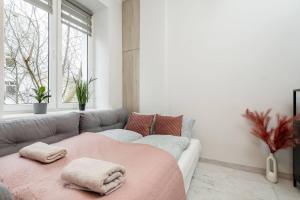 a living room with a couch and a pink blanket at Daisy Studio Stary Mokotow in Warsaw