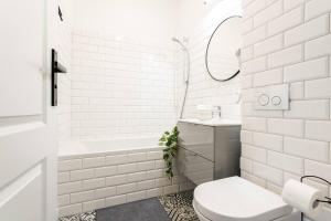 ein weißes Badezimmer mit einer Badewanne, einem WC und einem Waschbecken in der Unterkunft Moonlight Studio Stary Mokotow in Warschau