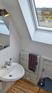 a bathroom with a sink and a window at Hüs bi Söl - Haus bei Sylt in Uphusum