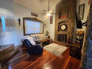 a living room with a couch and a stone fireplace at Colorado Cottage W/Mountain View in Colorado Springs