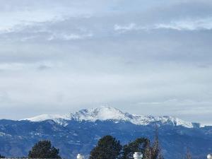 a snow covered mountain in the distance with trees in the foreground at Colorado Cottage W/Mountain View in Colorado Springs
