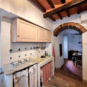 a kitchen with white cabinets and a counter top at antica abitazione con vista montagna Casa Norma in Seggiano
