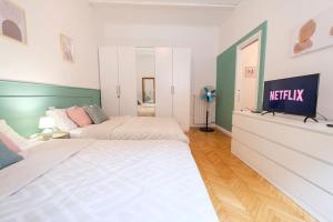 una camera con 2 letti e una TV a parete di [Cozy Double Suite] Milano Flat a Milano