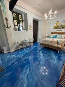 圣胡安The Suites & Vintage Apartment at Casa Of Essence in heart of Old San Juan的一间铺有蓝色地板的卧室,上面涂有鱼